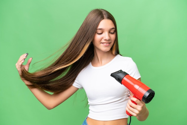 Garota adolescente caucasiana segurando um secador de cabelo sobre fundo isolado