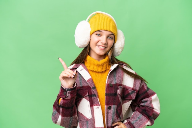 Garota adolescente caucasiana usando regalos de inverno sobre fundo isolado mostrando e levantando um dedo em sinal do melhor