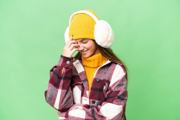 Garota adolescente caucasiana usando regalos de inverno sobre fundo isolado rindo