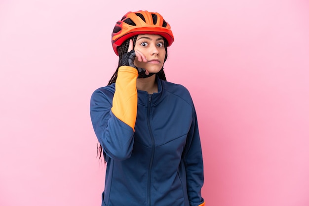 Foto garota adolescente ciclista isolada em fundo rosa, pensando em uma ideia