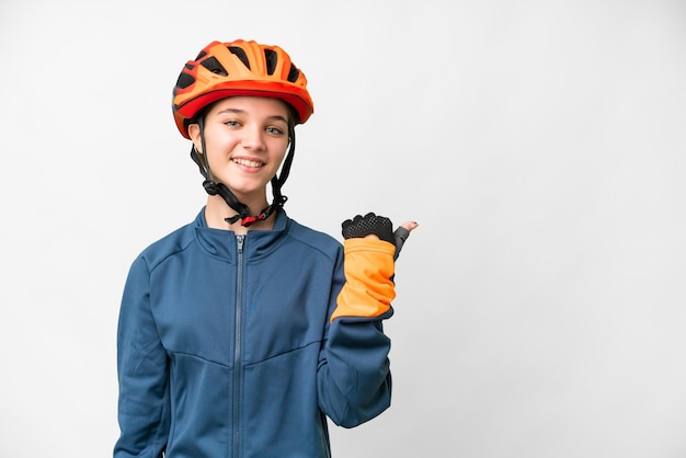 Garota adolescente ciclista sobre fundo branco isolado, apontando para o lado para apresentar um produto