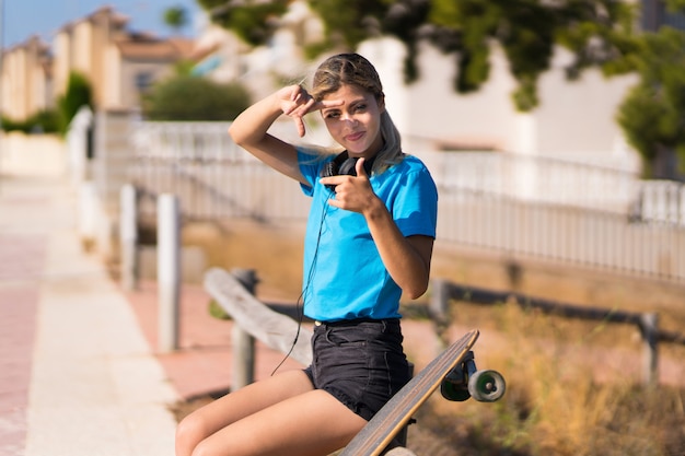 Garota adolescente com skate ao ar livre, focando o rosto. Símbolo de enquadramento