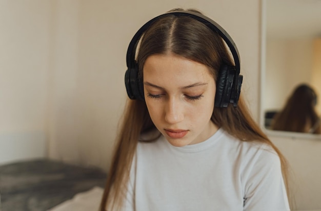 Garota adolescente de Portert geração z em fones de ouvido olha tristemente para baixo