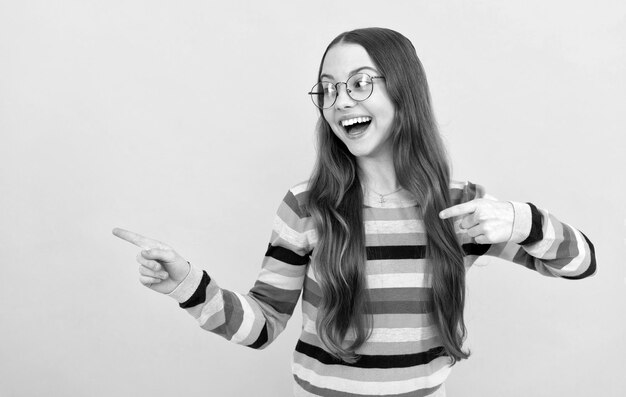 Garota adolescente feliz e inteligente em óculos apontando os dedos visão acuidade visão