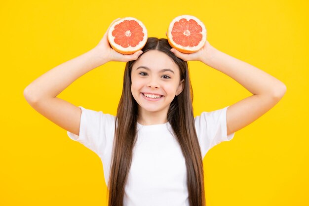 Garota adolescente feliz em camiseta segura toranja laranja crianças frutas vitamina