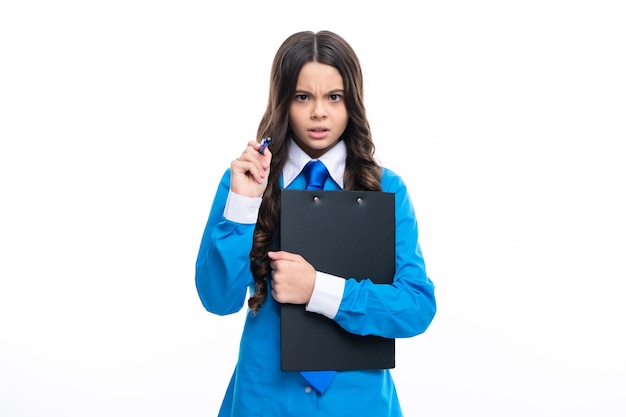 Garota adolescente irritada séria de camisa e gravata vestindo uniforme de escritório segurando a prancheta em fundo branco isolado