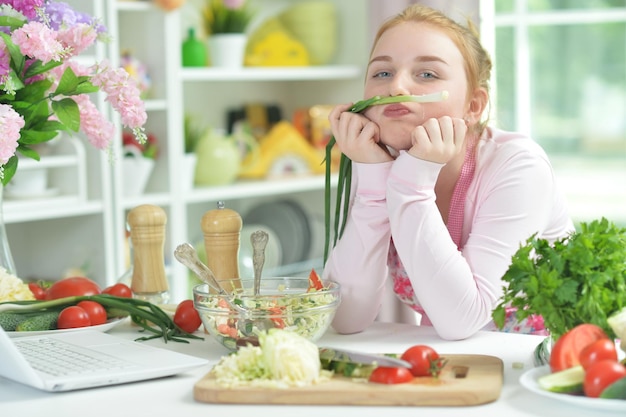 Garota adolescente preparando salada fresca