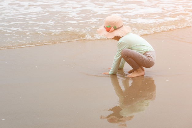 Foto garota adorável criança brincando com brinquedos de praia na praia de areia