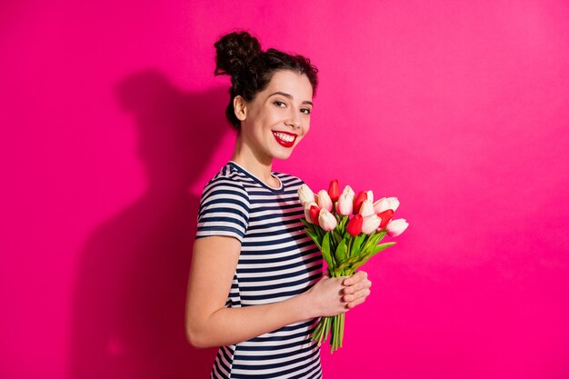 Garota adorável e alegre segurando um buquê natural de tulipas