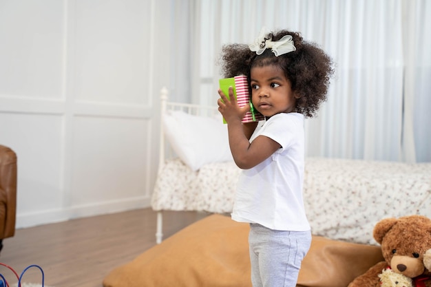 Garota africana Divirta-se brincando com os amigos do seu filho na sala de estar