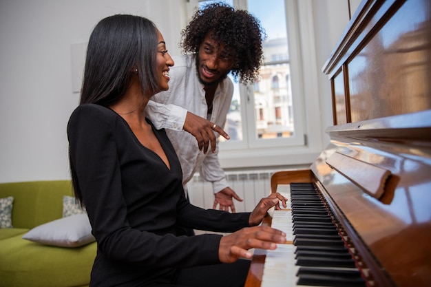 Garota africana toca piano com sua amiga que gosta de música