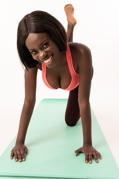 Garota afro-americana atraente no sportswear está fazendo yoga