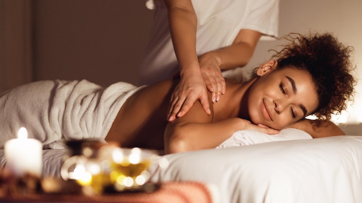 Foto garota afro-americana desfrutando de relaxante massagem nas costas e aromaterapia no centro de spa