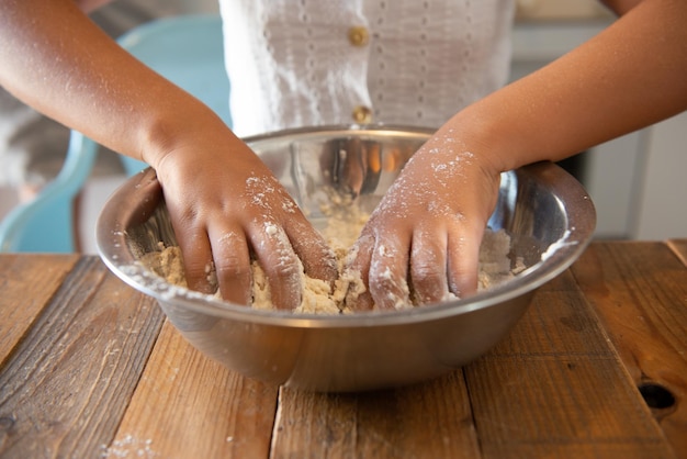 Garota afro-americana em sua cozinha de casa fazendo uma massa de pastelaria