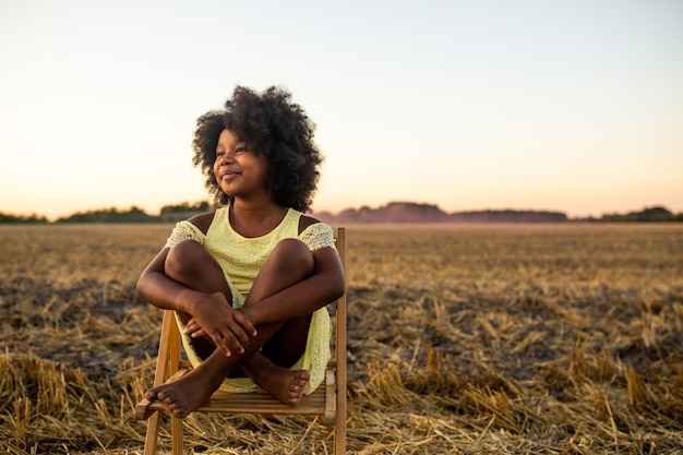 Foto garota afro-americana em um campo de girassóis se divertindo