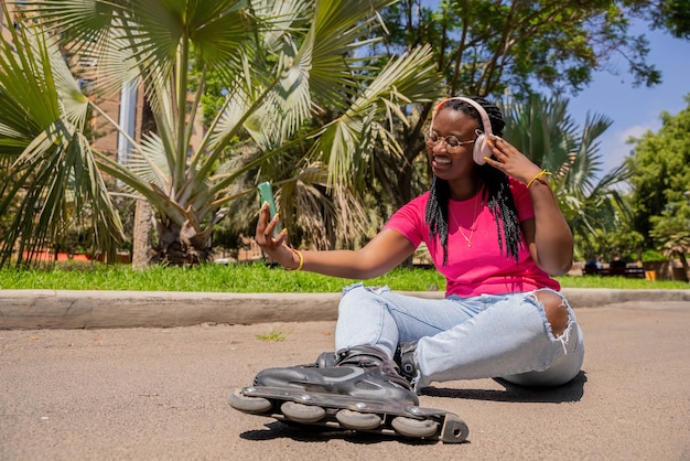 Garota afro-americana fazendo videochamada com patins