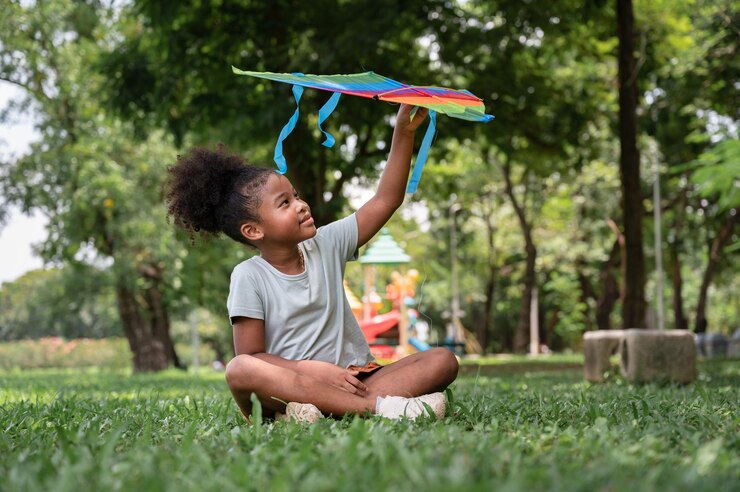 Foto garota afro-americana joga pipa no parque