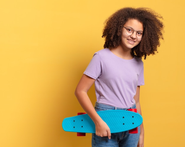 Garota afro bonita com uma prancha de skate