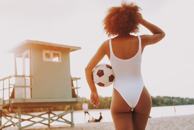 Garota Afro em Sexy Swimsuit olhando pela praia