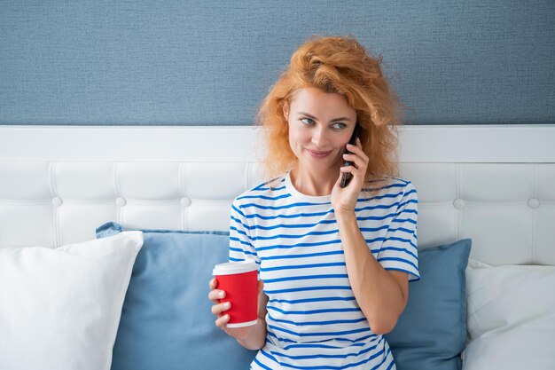 Garota alegre com café fala no telefone garota em casa falando no telefone falando no telefone garota