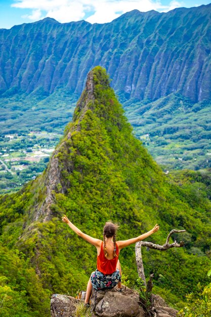 Foto garota alpinista fica no topo da trilha olomana ridge admirando o panorama das montanhas oahu e havaí