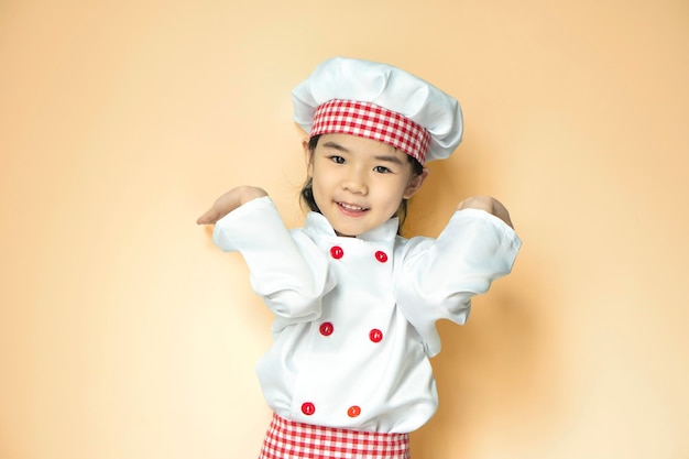 Garota asiática sorridente vestindo uniforme de chef