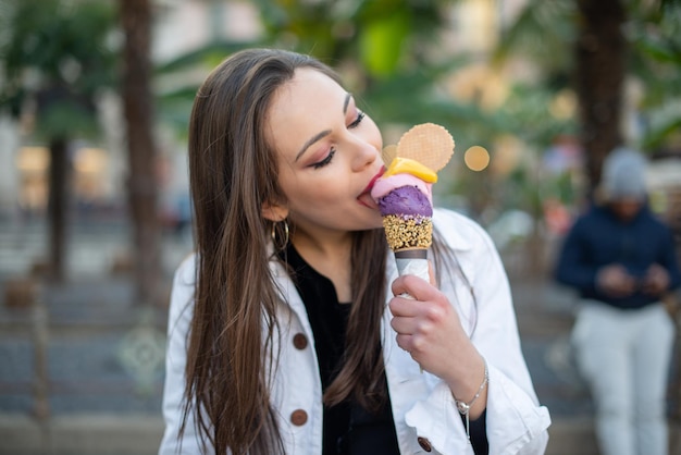 Garota atraente comendo sorvete na rua da cidade