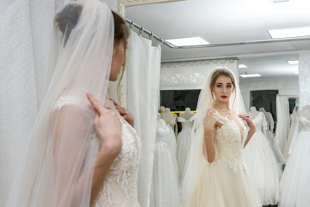 Garota atraente no espelho em uma loja de casamento