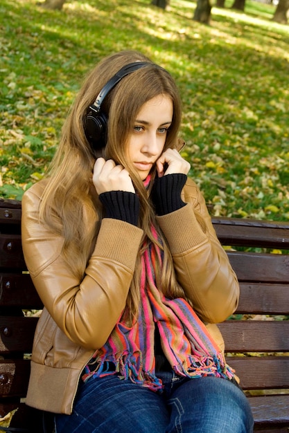 Garota atraente no parque ouve música