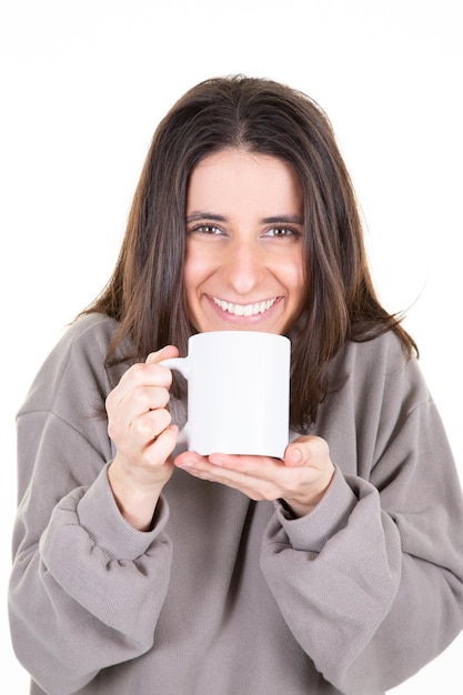 Foto garota atraente segurando uma caneca de bebida quente branca em fundo branco