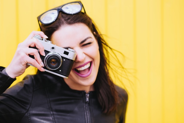 Garota atraente tira fotos com uma câmera antiga