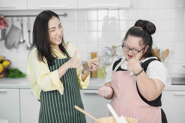 Garota autista. Garota autista praticando cozinhar com a mãe na cozinha.