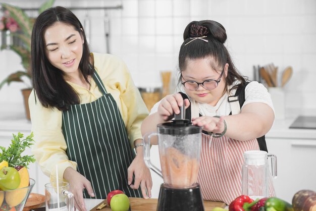 Garota autista. Garota autista praticando cozinhar com a mãe na cozinha.