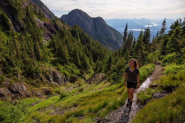 Foto garota aventureira caminhando pela trilha na paisagem montanhosa canadense