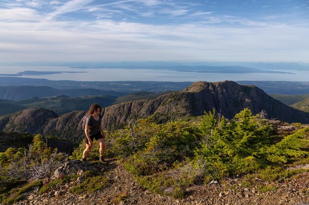 Garota aventureira caminhando pela trilha na paisagem montanhosa canadense