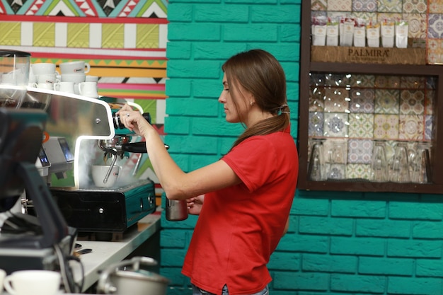 Foto garota barista prepara café na máquina de café.