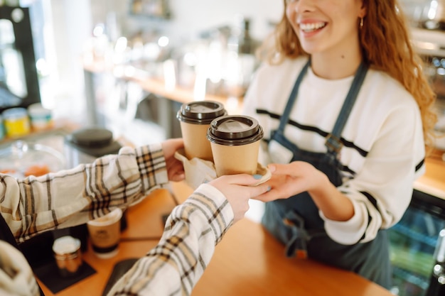 Foto garota barista segurando café para levar na cafeteria comida para viagem