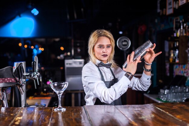 Garota barman faz um coquetel na cervejaria