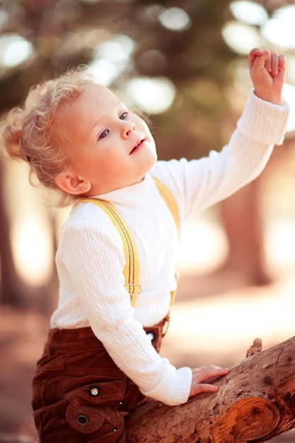 Garota bonita e bonita de 4 a 5 anos de idade com roupas casuais de outono ao ar livre no parque