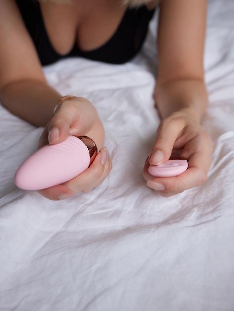 garota bonita em roupas sexy segurando em suas mãos um brinquedo sexual para adultos
