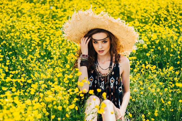 garota bonita em um campo de flores amarelas