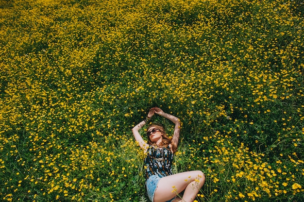 Garota bonita em um campo de flores amarelas