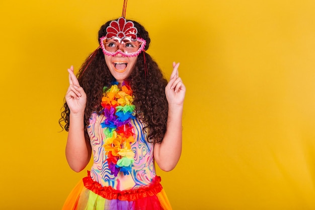 Garota brasileira caucasiana vestida para o carnaval Dedos cruzados desejando esperança