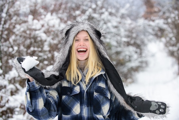 Garota brincando com neve garota de luvas segurando uma bola de neve Mulher feliz segurando uma bola de neve nas mãos no inverno