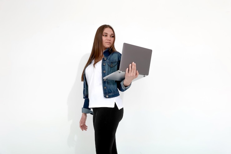 Foto garota bronzeada com um laptop em um fundo branco freelancer mockup de trabalho remoto