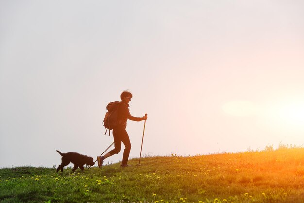 Garota caminha nas montanhas com seu cachorro