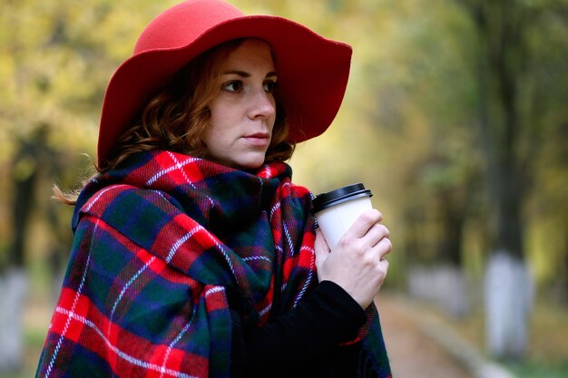 Garota caminhando em um parque de outono durante uma folha de outono