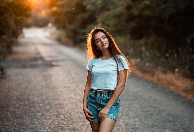 Garota casual sorrindo e curtindo a vida ao pôr do sol