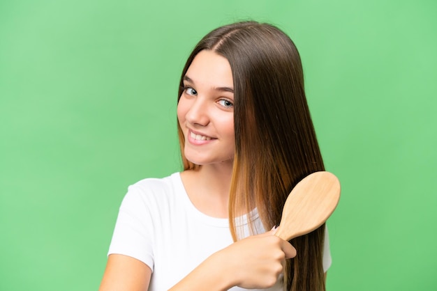 Garota caucasiana adolescente com pente de cabelo sobre fundo isolado