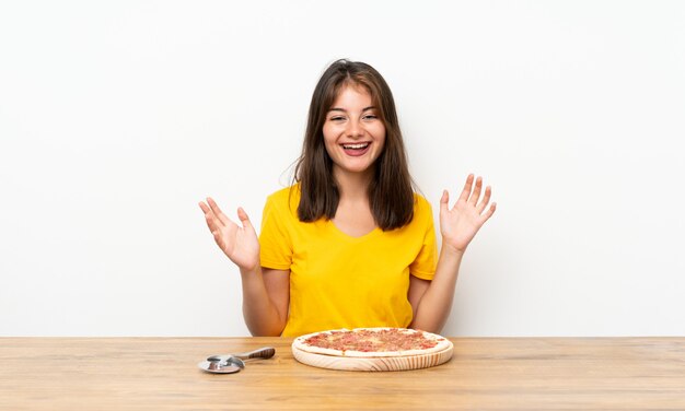 Foto garota caucasiana com uma pizza rindo